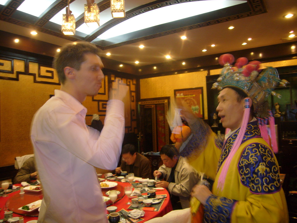 Tim getting a drink as part of a ritual being performed in a restaurant near Luoyang