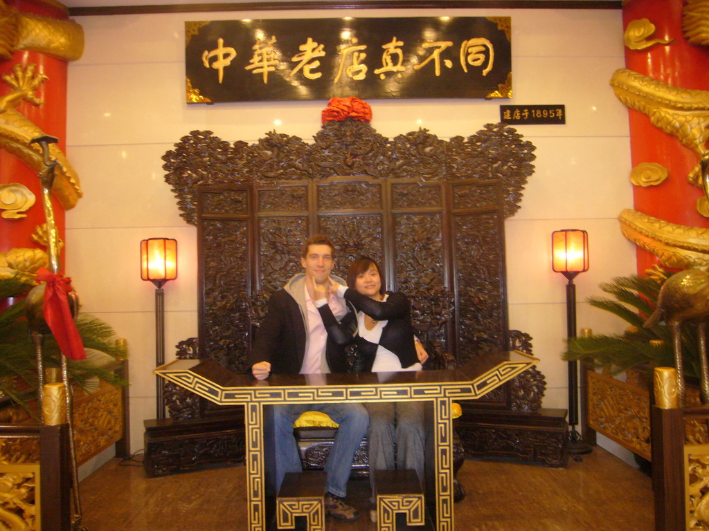 Tim and Miaomiao on a throne in a restaurant near Luoyang