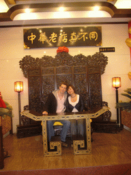 Tim and Miaomiao on a throne in a restaurant near Luoyang