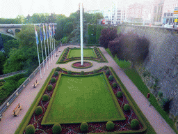 Garden with the flags of Luxembourg and the European Union and the Pont Adolphe bridge over the Vallée de la Pétrusse valley, viewed from the Place de la Constitution square