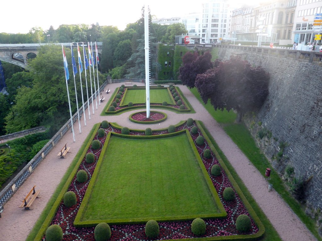 Garden with the flags of Luxembourg and the European Union and the Pont Adolphe bridge over the Vallée de la Pétrusse valley, viewed from the Place de la Constitution square