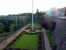 Garden with the flags of Luxembourg and the European Union and the Pont Adolphe bridge over the Vallée de la Pétrusse valley, viewed from the Place de la Constitution square