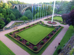 Garden with the flags of Luxembourg and the European Union and the Pont Adolphe bridge over the Vallée de la Pétrusse valley, viewed from the Place de la Constitution square