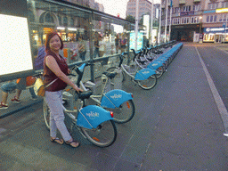 Miaomiao with her rental bike at the Place de la Gare, at sunset