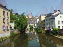 The Alzette-Uelzecht river, houses at the Grund district, the Casemates du Bock and Saint Michael`s Church, viewed from the Rue Münster bridge