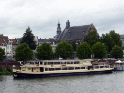 Boat in the Maas river and the city center with the Augustijnenkerk church, viewed from the Sint Servaasbrug bridge
