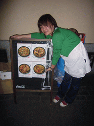 Miaomiao at a poster with paella plates, in a restaurant in the city center