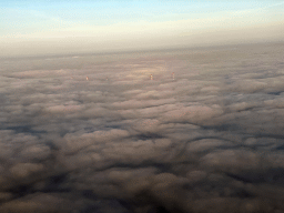 Factory chimneys above the clouds, viewed from the airplane to Eindhoven