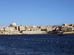 Boat in Marsamxett Harbour and Valletta with the dome of the Carmelite Church and the tower of St Paul`s Pro-Cathedral