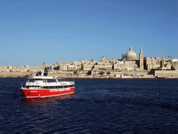 Boat in Marsamxett Harbour and Valletta with the dome of the Carmelite Church and the tower of St Paul`s Pro-Cathedral