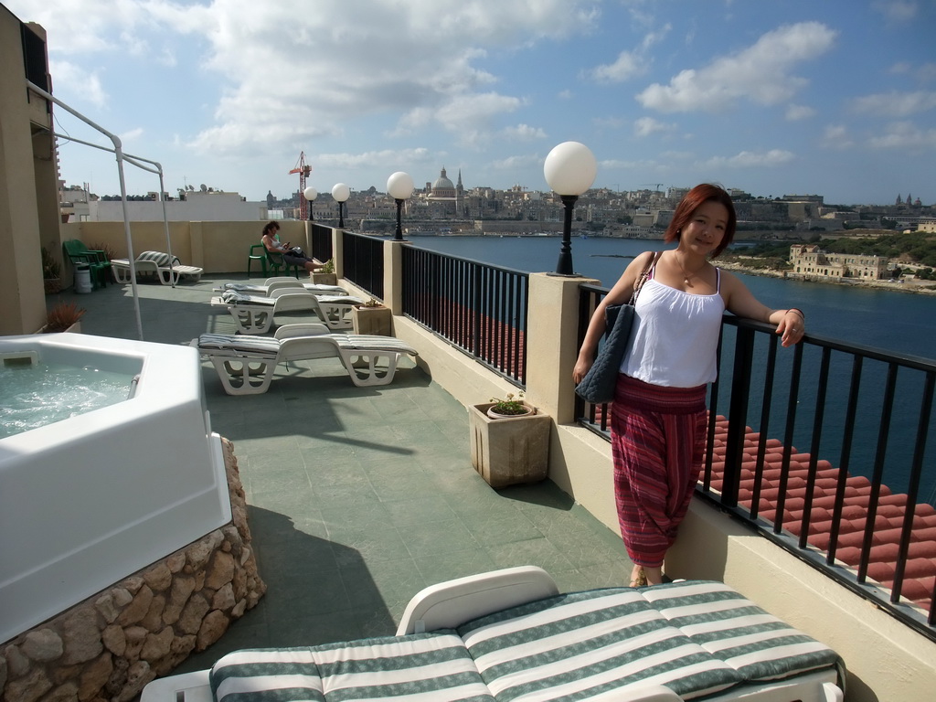 Miaomiao with the jacuzzi at the roof terrace of the Marina Hotel, with a view on Marsamxett Harbour, Manoel Island and Valletta with the dome of the Carmelite Church and the tower of St Paul`s Pro-Cathedral