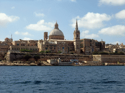 Marsamxett Harbour and Valletta with the dome of the Carmelite Church and the tower of St Paul`s Pro-Cathedral, viewed from the Luzzu Cruises tour boat from Sliema to Marsaxlokk