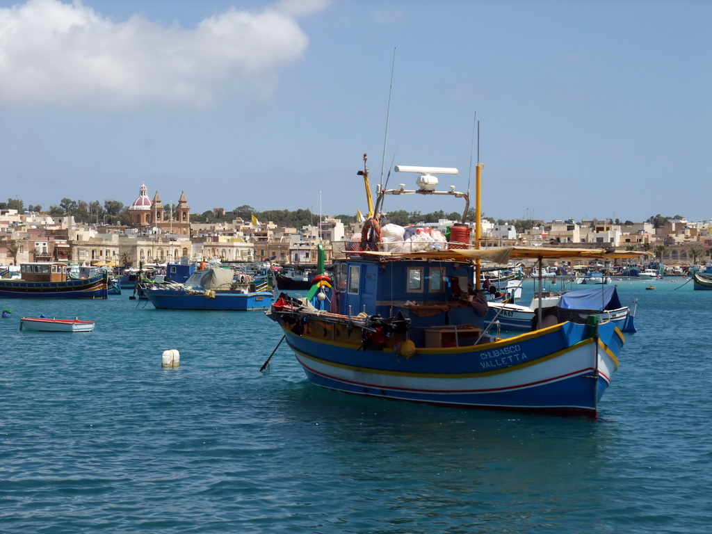 Fishing boats in the harbour of Marsaxlokk and the Church of Our Lady of Pompeii, viewed from the Luzzu Cruises tour boat from Sliema to Marsaxlokk