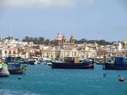 Fishing boats in the harbour of Marsaxlokk and the Church of Our Lady of Pompeii, viewed from the Luzzu Cruises tour boat from Sliema to Marsaxlokk