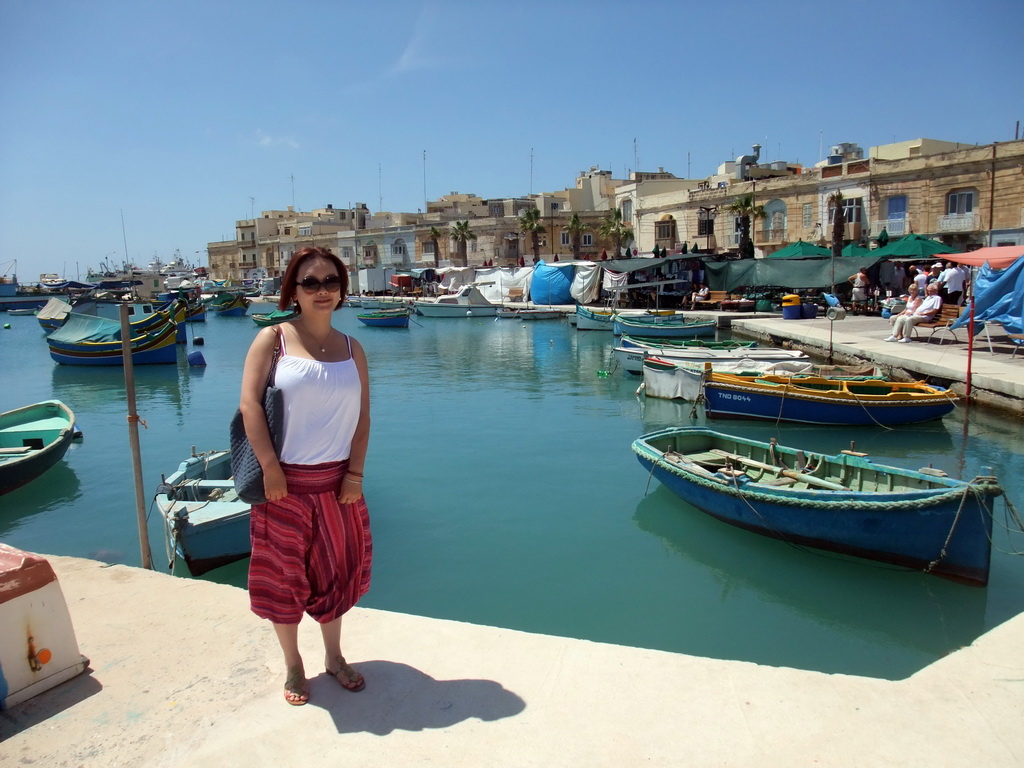 Miaomiao with the fish market and fishing boats at the harbour of Marsaxlokk
