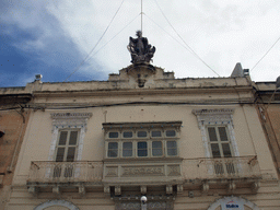 House with balcony and statue at San Pawl street in Sliema