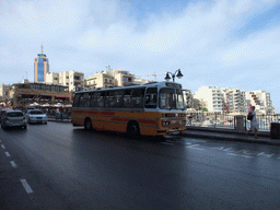 Yellow bus at Spinola Bay in St. Julian`s (San Giljan), with the Hilton Malta Hotel
