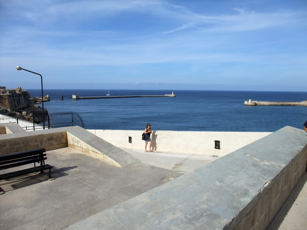 Miaomiao near the Siege Bell Monument at Valletta, with a view on the Grand Harbour with the pier at Fort Saint Elmo and the pier at Fort Ricasoli