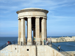 The Siege Bell Monument, the Grand Harbour and Fort Ricasoli, viewed from the Lower Barracca Gardens at Valletta