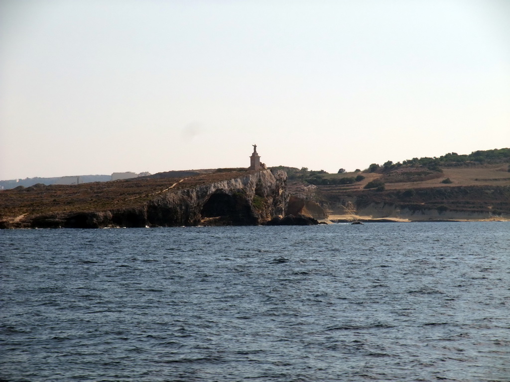 St Paul`s Island with the statue of St. Paul, viewed from the Luzzu Cruises tour boat from Comino to Malta