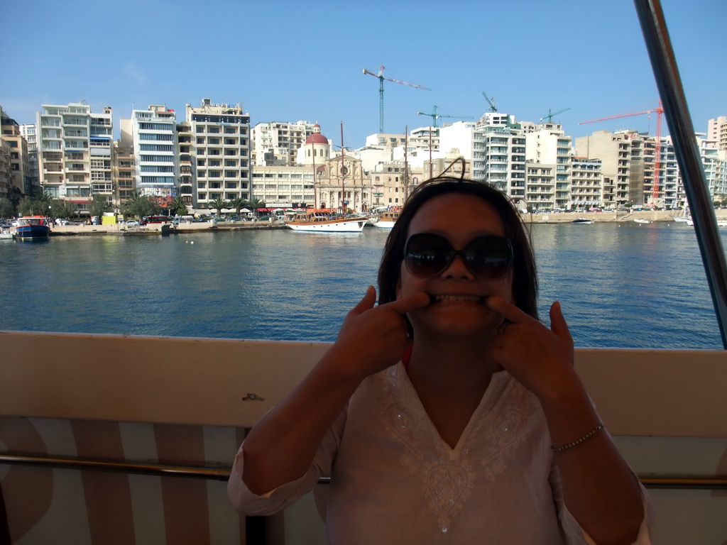 Miaomiao on the Luzzu Cruises tour boat from Comino to Malta, with a view on the Tigné Seafront with the front of the Marina Hotel and the Parish Church of Jesus of Nazareth