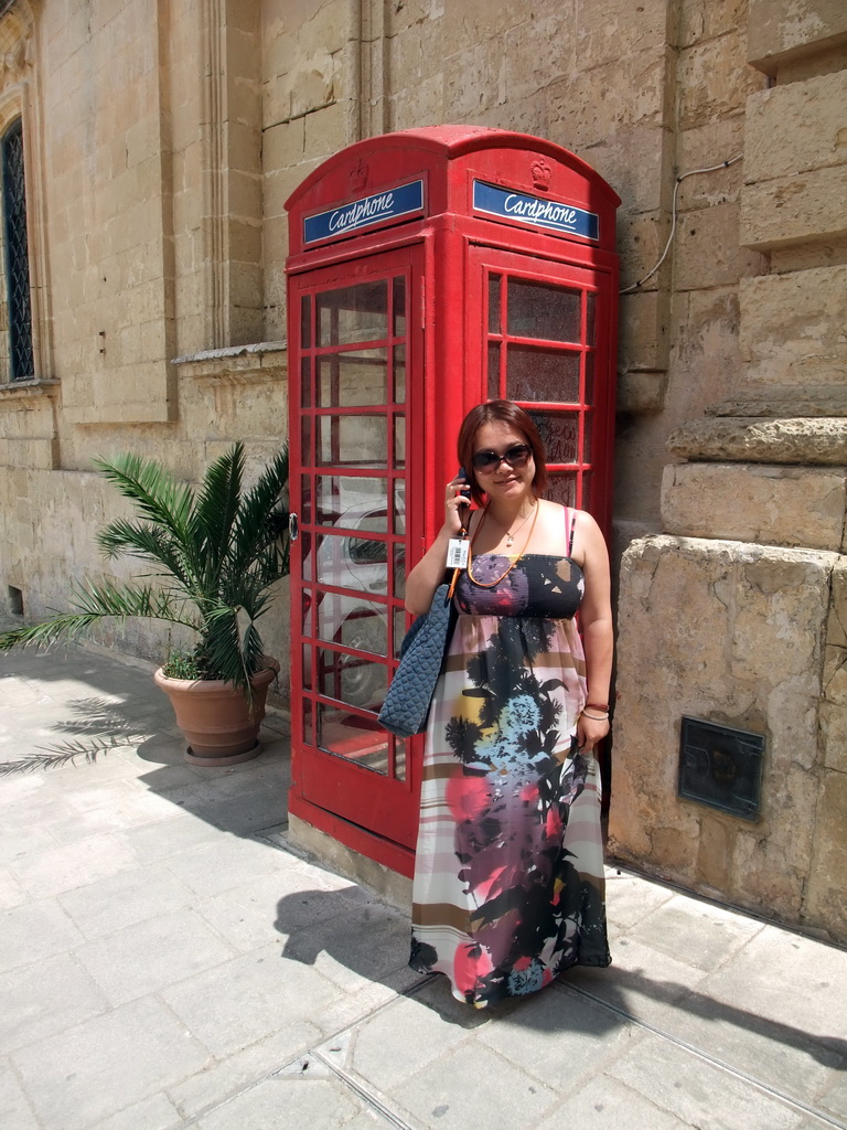 Miaomiao at a telephone booth at St. Paul`s Square at Mdina