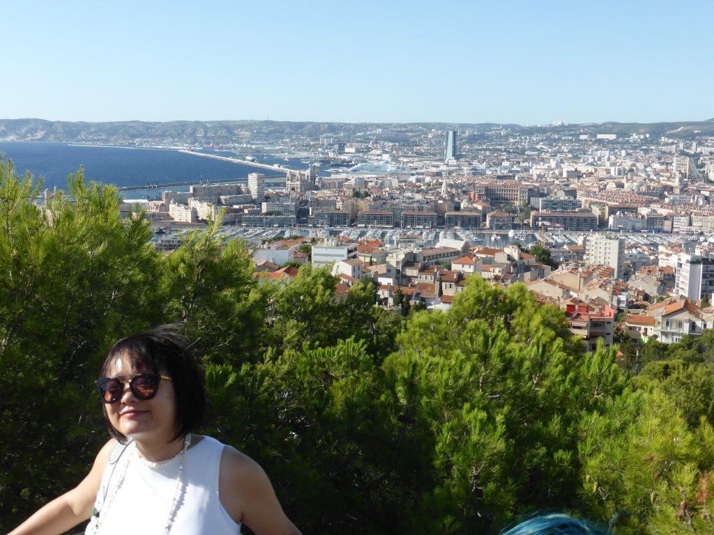 Miaomiao at the road to the Notre-Dame de la Garde basilica, with a view on the Old Port, the harbour of Marseille, the CMA CGM Tower and the Marseille Cathedral