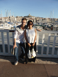 Tim and Miaomiao at the Quai du Port street with a view on the boats in the Old Port and the Notre-Dame de la Garde basilica