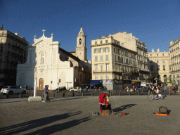 Street artist and the front of the Église des Augustins church at the Quai des Belges street