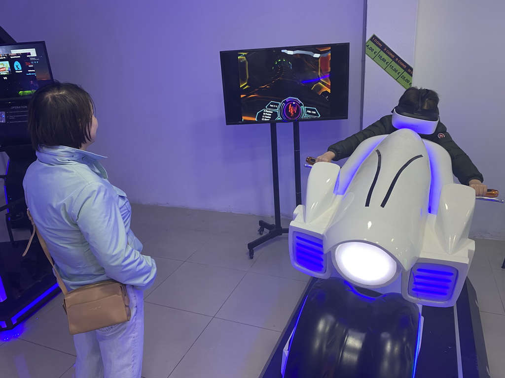 Miaomiao and Max doing a virtual reality motor cycle game at the VR Arena at the Yumbo Centrum shopping mall