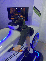 Max doing a virtual reality motor cycle game at the VR Arena at the Yumbo Centrum shopping mall