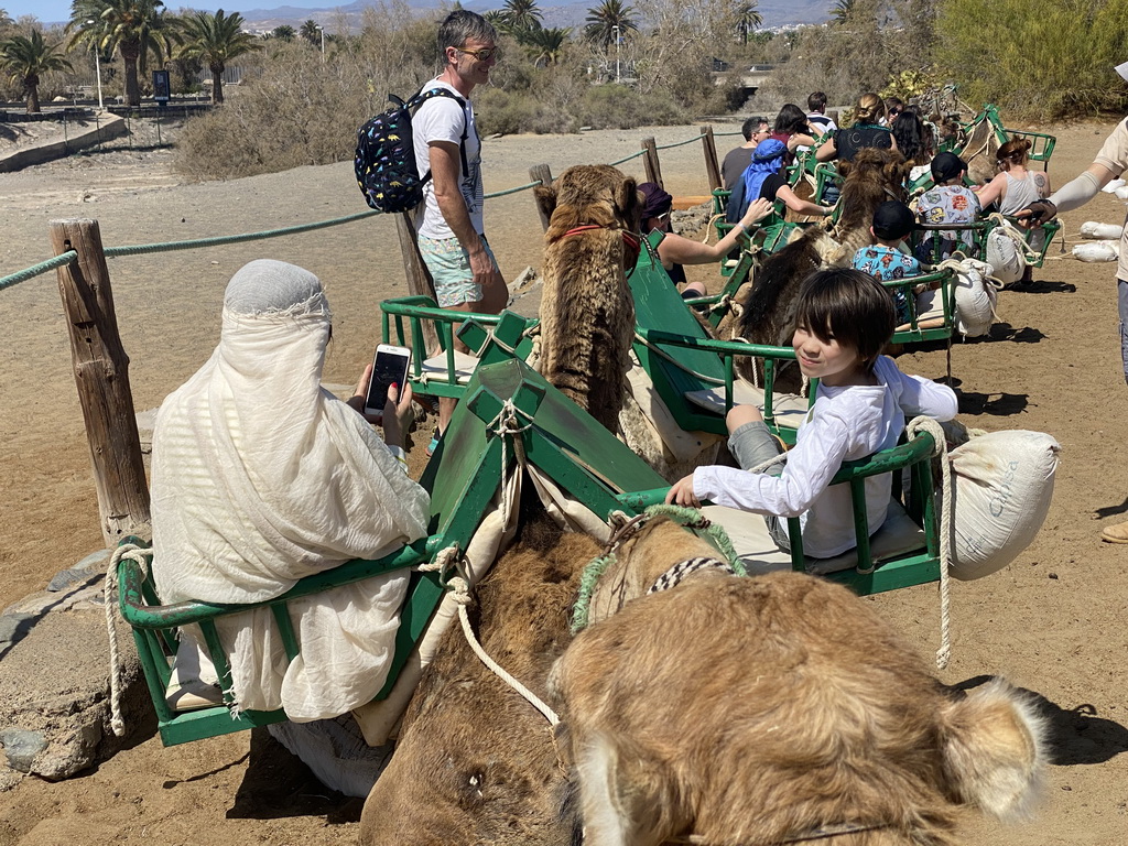 Miaomiao and Max on their Dromedary at the starting point of the Camel Safari, viewed from Tim`s Dromedary