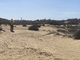 Guide at the Maspalomas Dunes, the Faro de Maspalomas lighthouse and the towers of the Lopesan Costa Meloneras Resort, Spa & Casino, viewed from Tim`s Dromedary, during the Camel Safari