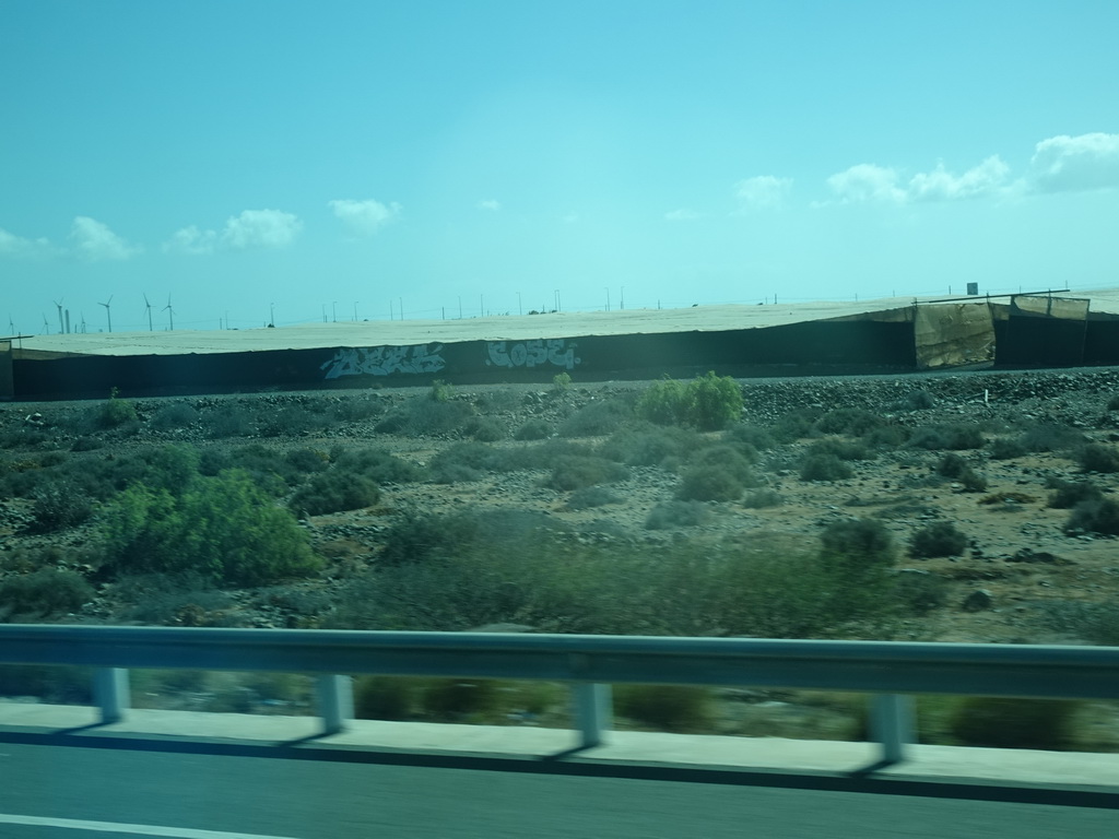 Greenhouses and windmills near the Cañada de la Cebolleta ravine, viewed from the bus to Las Palmas at the GC-1 road
