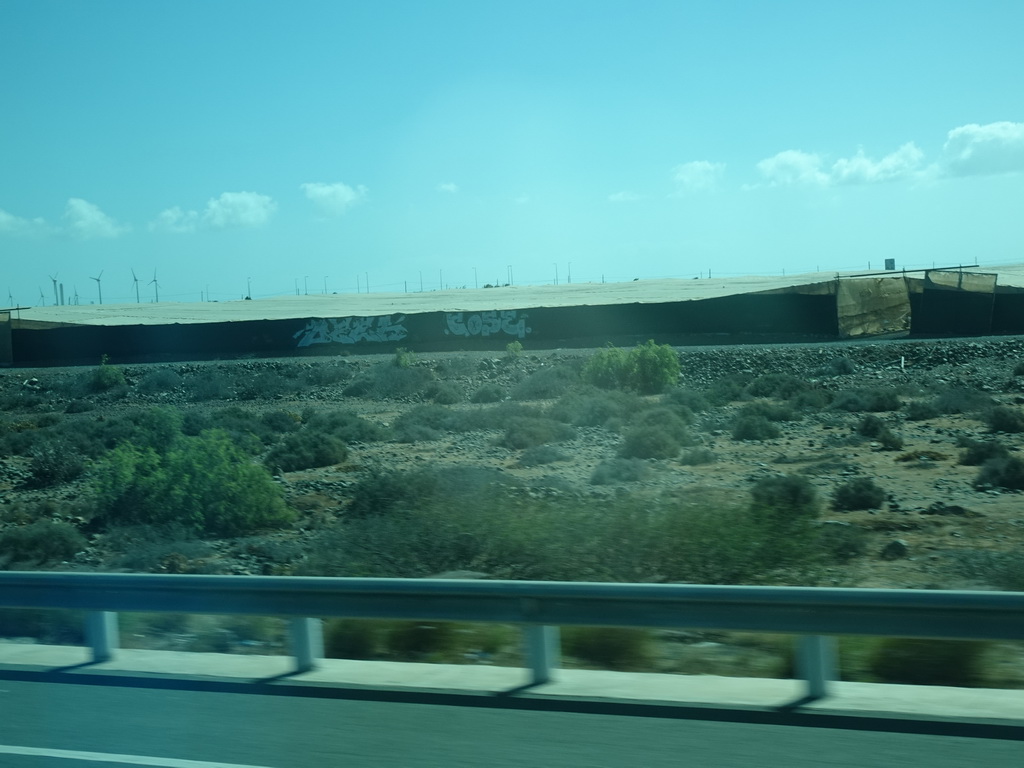 Greenhouses and windmills near the Cañada de la Cebolleta ravine, viewed from the bus to Las Palmas at the GC-1 road