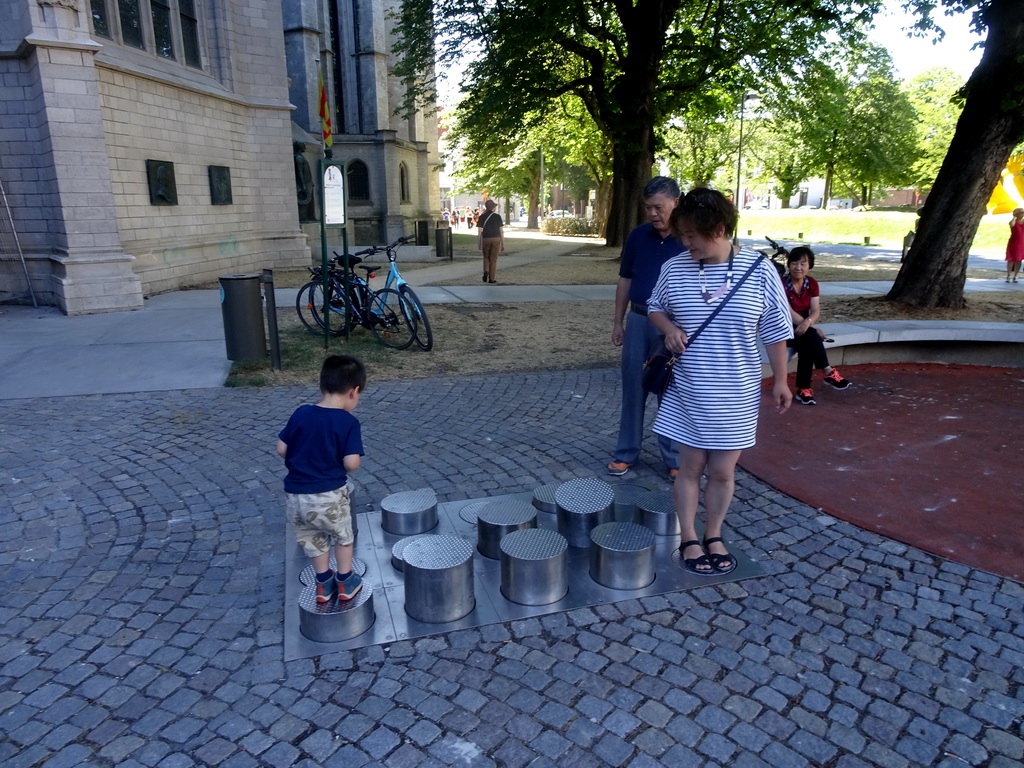 Miaomiao, Max and Miaomiao`s parents on a playground on the Sint-Romboutskerkhof square