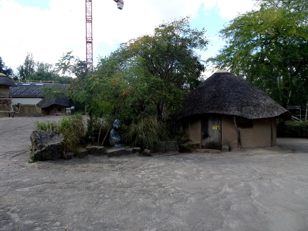 Statue and houses at the African Village at the Africa section of ZOO Planckendael