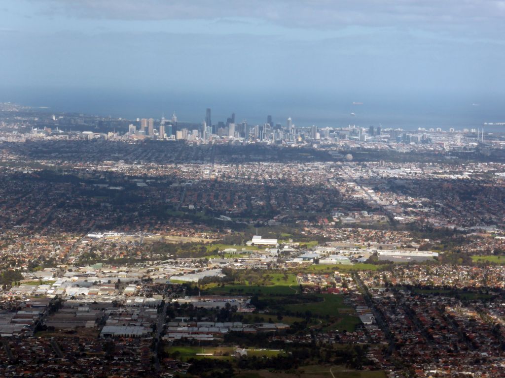 The north side of the city with Merri Creek and the Coburg Drive-In Theatre, skyscrapers in the city center and the coastline, viewed from the airplane from Sydney