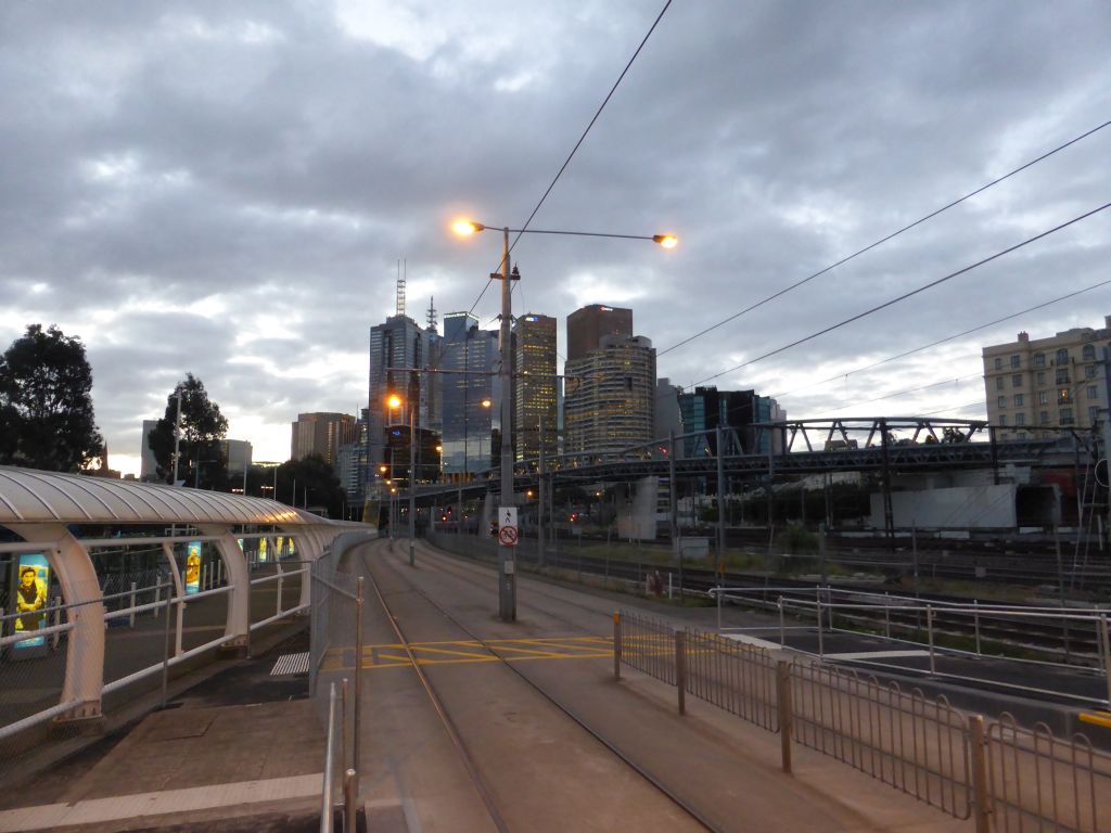 The Rod Laver Arena / Melbourne Park tram stop, the railway and skyscrapers in the city center, at sunset