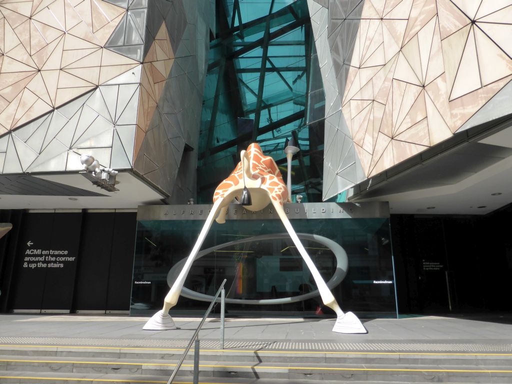 Statue of Melman the Giraffe from the movie `Madagascar` in front of the Australian Centre for the Moving Image at Flinders Street