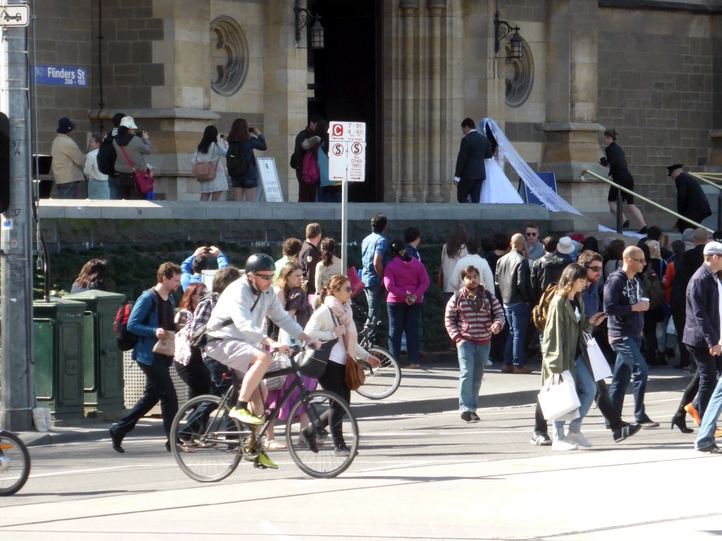 Bride and groom in front of St. Paul`s Cathedral at the crossing of Flinders Street and Swanston Street