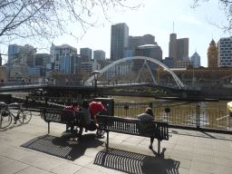 The Southbank Promenade, the Southgate pedestrian bridge over the Yarra River, the Flinders Street Railway Station and skyscrapers in the city center