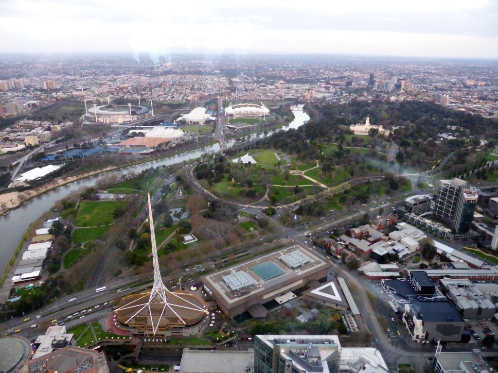 The Spire of the Arts Centre Melbourne, the National Gallery of Victoria, the Queen Victoria Gardens, the Kings Domain with the Government House, the Melbourne Cricket Ground, the Rod Laver Arena, Melbourne Park, the Hisense Arena, the AAMI Park and the Yarra River, viewed from the Skydeck 88 of the Eureka Tower