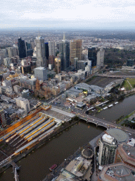 Skyscrapers at the city center, the Flinders Street Railway Station, St. Paul`s Cathedral, Federation Square with the Australian Centre for the Moving Image, the Princess Bridge over the Yarra River and the Fitzroy Gardens, viewed from the Skydeck 88 of the Eureka Tower, at sunset