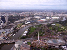 The Spire of the Arts Centre Melbourne, the National Gallery of Victoria, the Queen Victoria Gardens, the Kings Domain, the Melbourne Cricket Ground, the Rod Laver Arena, Melbourne Park, the Hisense Arena, the AAMI Park, the Fitzroy Gardens and the Princess Bridge over the Yarra River, viewed from the Skydeck 88 of the Eureka Tower, at sunset