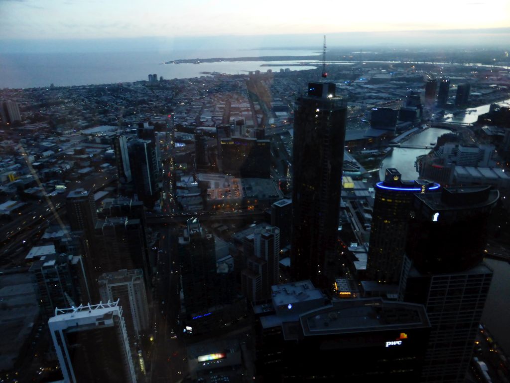 The southwest side of the city with the Freshwater Place building, the Prima Pearl Tower, the Port of Melbourne, the Seafarers Bridge and the Charles Grimes Bridge over the Yarra River and Hobsons Bay, viewed from the Skydeck 88 of the Eureka Tower, at sunset