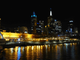 Skyscrapers at the city center, St. Paul`s Cathedral, the Flinders Street Railway Station and the Yarra River, viewed from the South Warf Promenade, by night