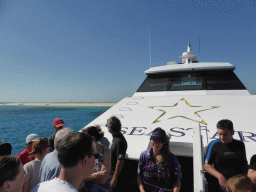 Tour guide and tourists on the deck of our Seastar Cruises tour boat, with a view on Michaelmas Cay