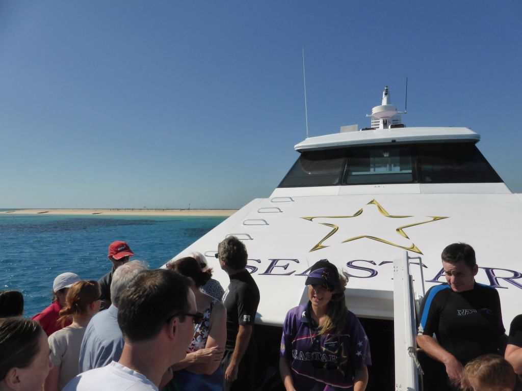 Tour guide and tourists on the deck of our Seastar Cruises tour boat, with a view on Michaelmas Cay