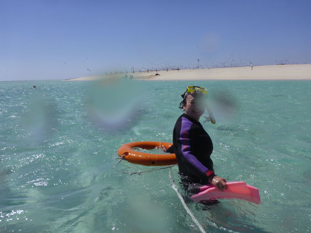 Miaomiao with snorkeling equipment in the water in front of Michaelmas Cay